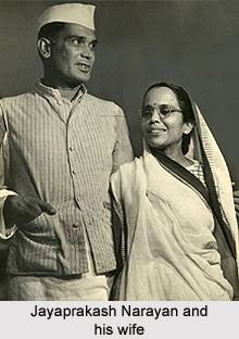 Photograph of Jaya Prakash Narayan in a Gandhi cap standing beside Prabhavati Devi in a sari